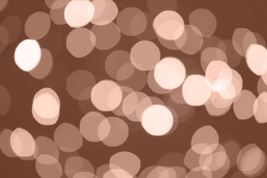 Image of Blurred bokeh lights toned in mocha mousse shade. Trendy color of 2025 year