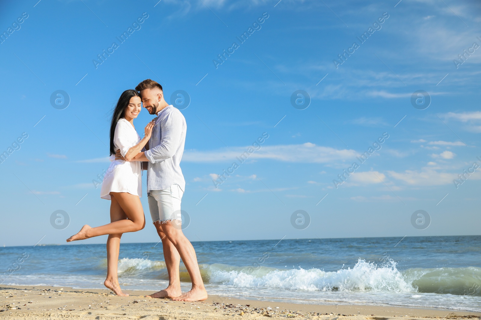 Photo of Happy young couple at beach on sunny day