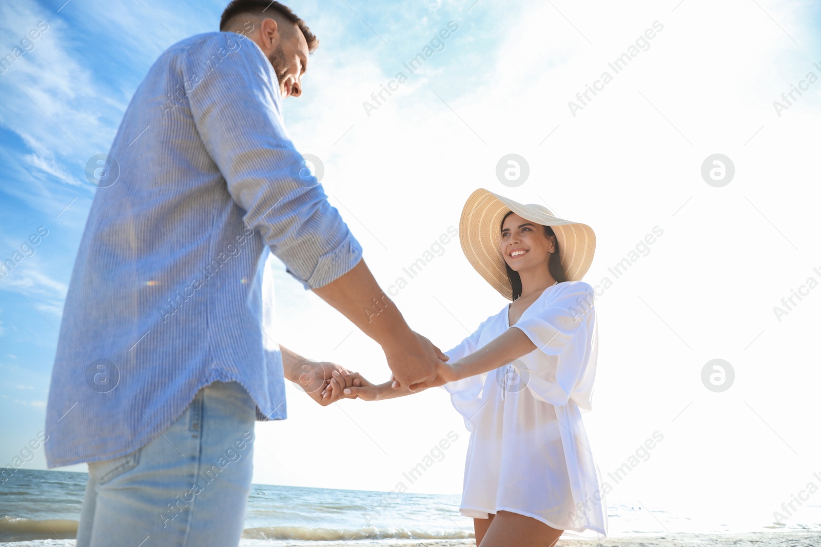 Photo of Happy couple holding hands on beach, low angle view