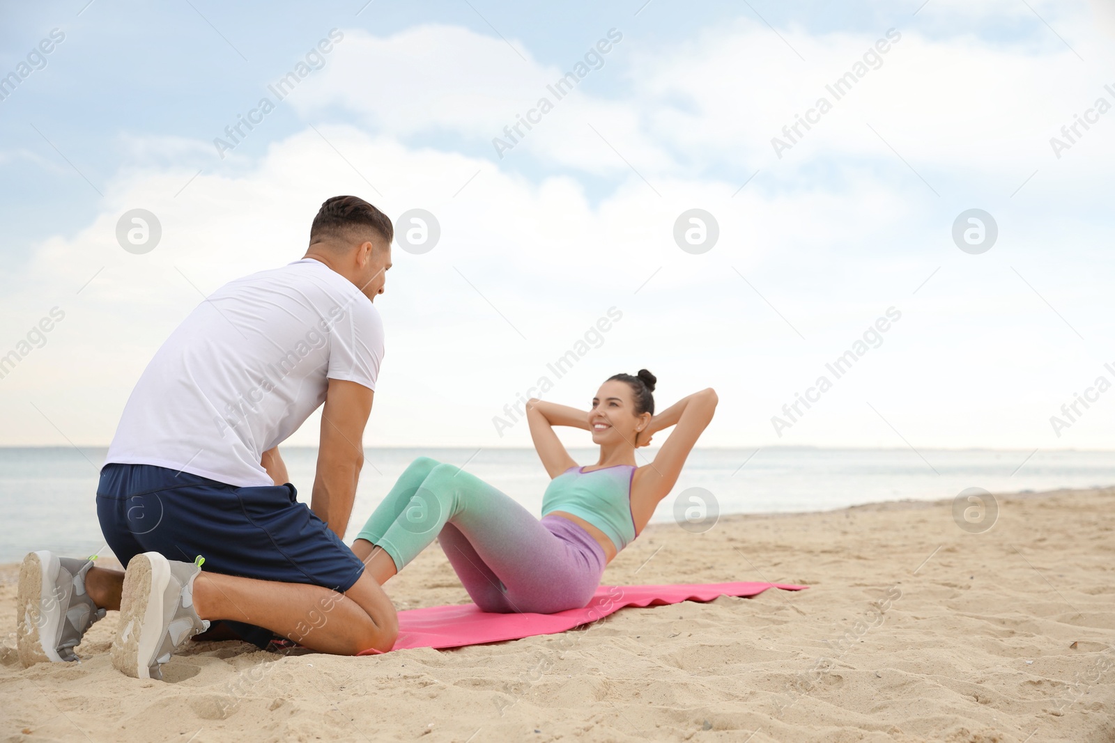 Photo of Couple doing exercise together on beach, space for text. Body training