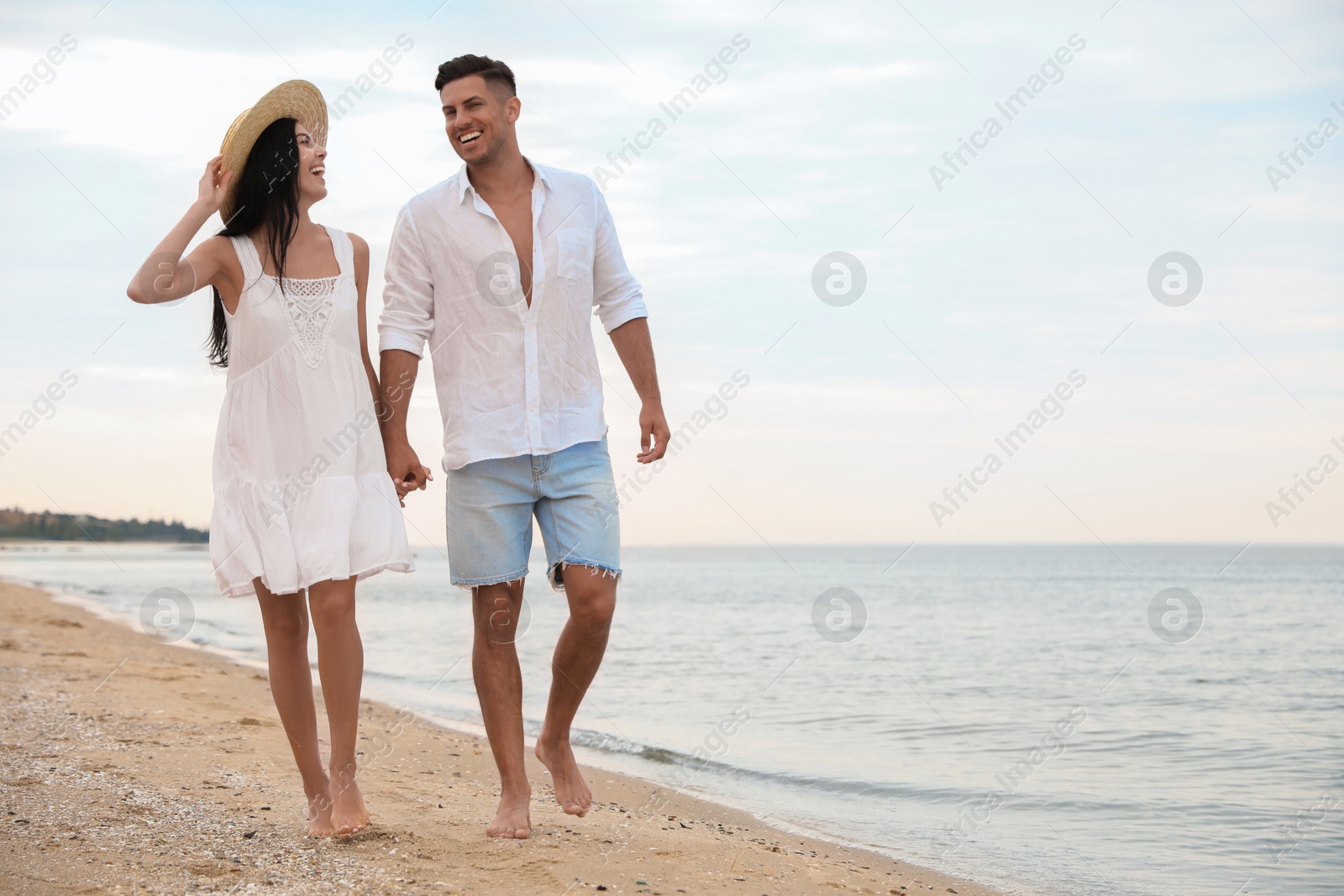 Photo of Lovely couple walking on beach. Space for text