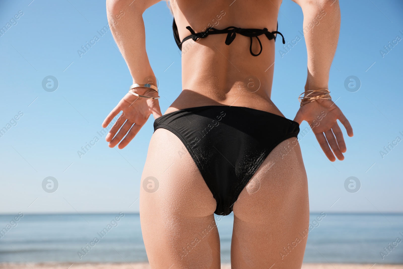 Photo of Young woman with beautiful body on beach, closeup