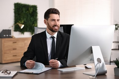 Photo of Man working with document at table in office