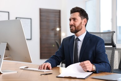 Photo of Man working on computer at table in office