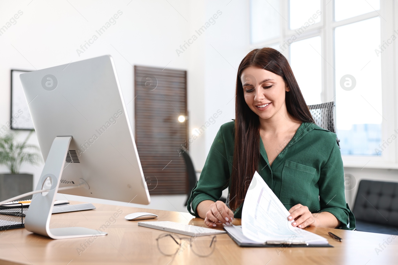 Photo of Woman working with document at table in office