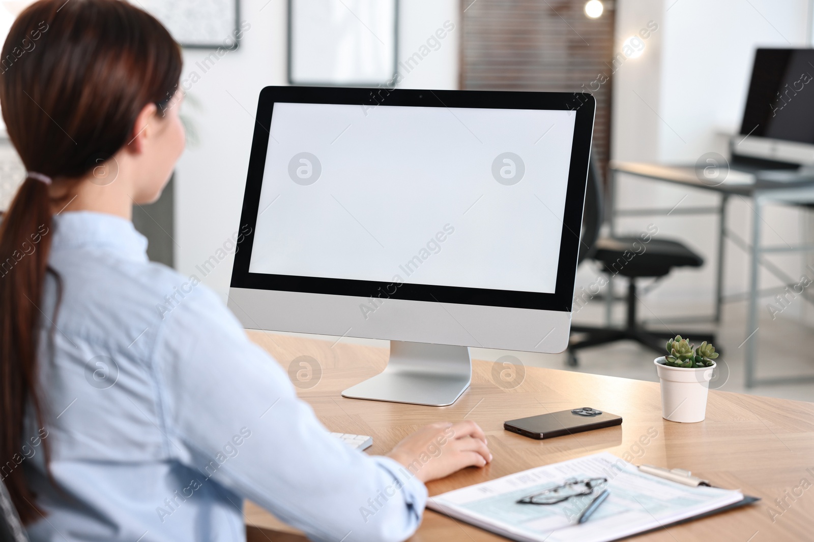 Photo of Woman working on computer at table in office