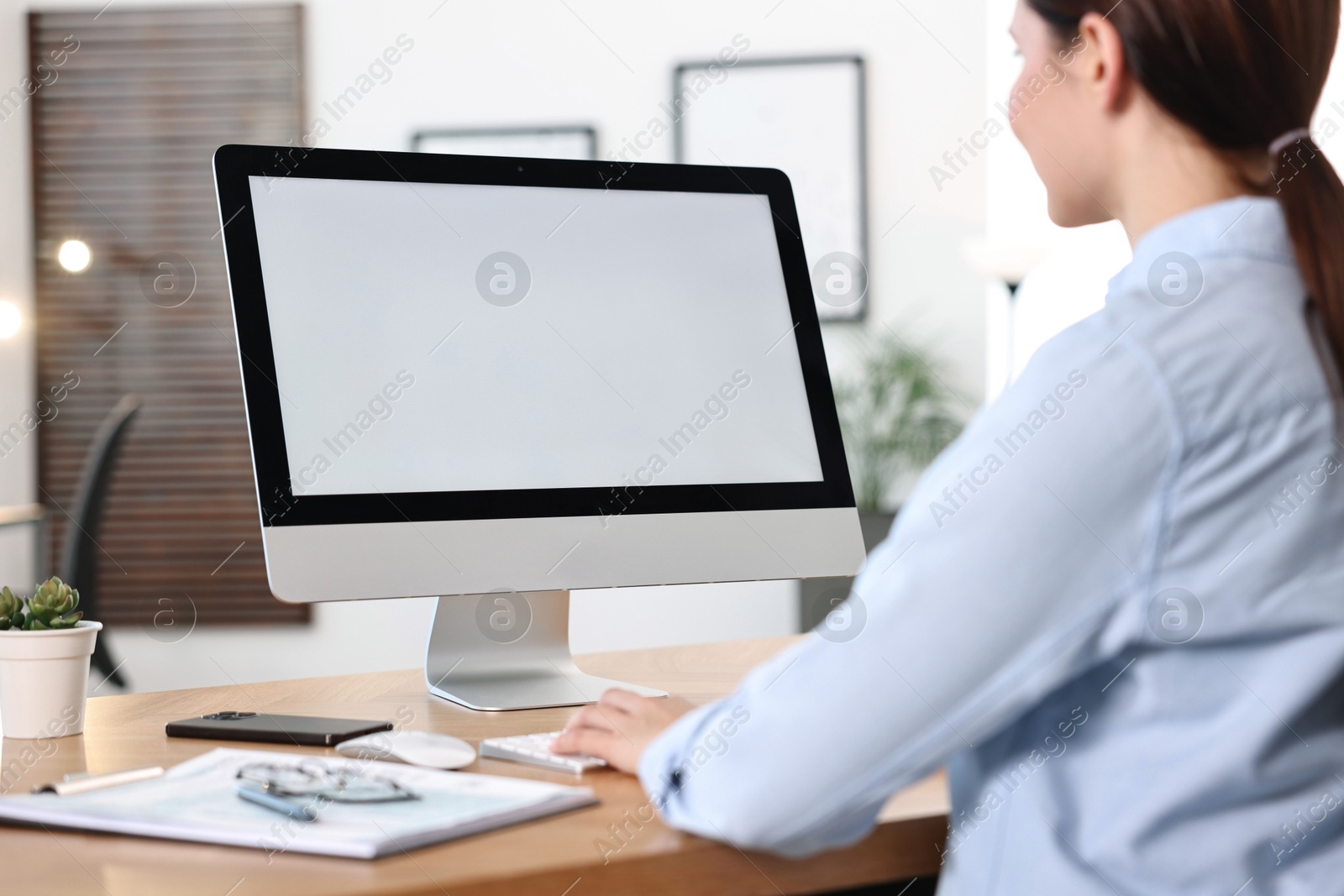 Photo of Woman working on computer at table in office