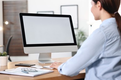 Photo of Woman working on computer at table in office