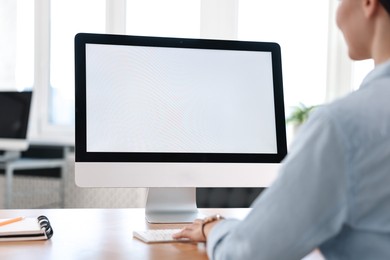 Photo of Woman working on computer at table in office, closeup