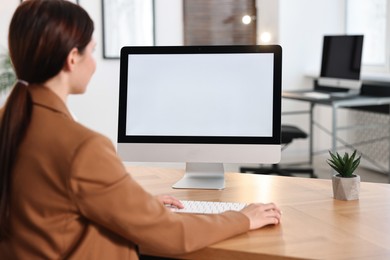 Photo of Woman working on computer at table in office