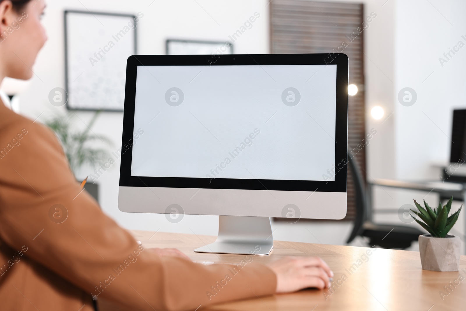 Photo of Woman working on computer at table in office, closeup