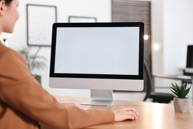 Photo of Woman working on computer at table in office, closeup