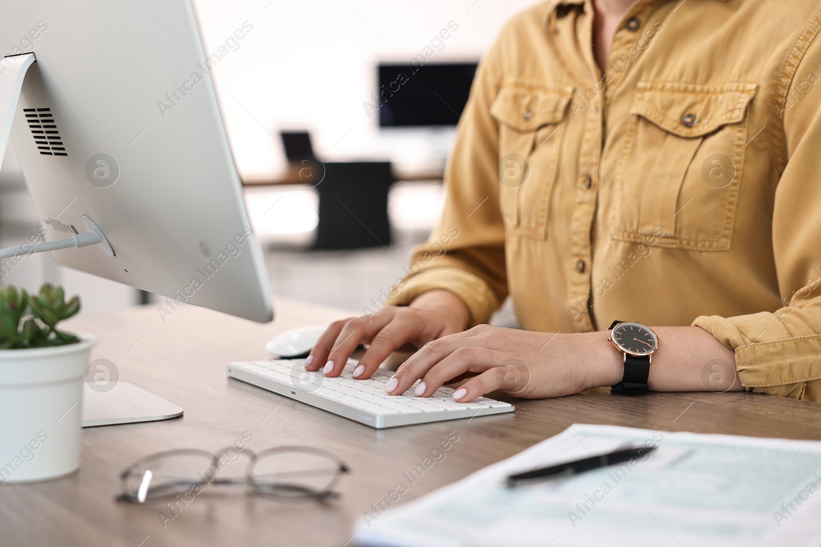 Photo of Woman working on computer at table in office, closeup