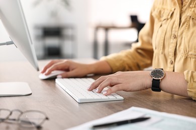 Photo of Woman working on computer at table in office, closeup