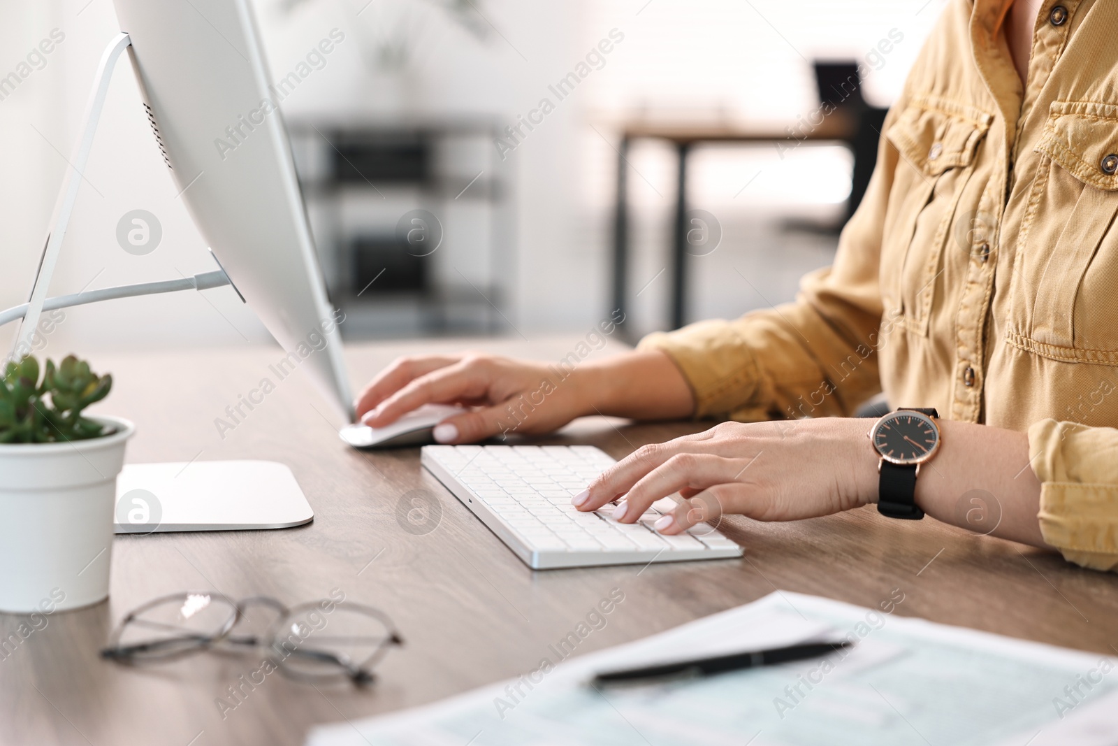 Photo of Woman working on computer at table in office, closeup