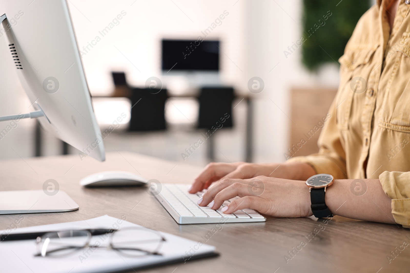 Photo of Woman working on computer at table in office, closeup