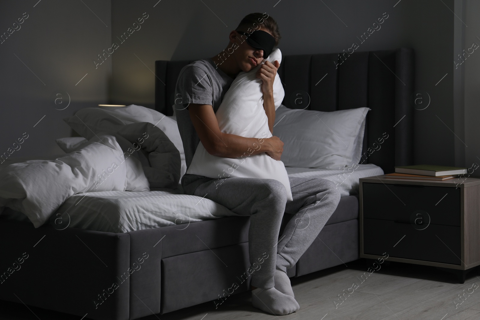 Photo of Young man suffering from sleepwalking on bed at home