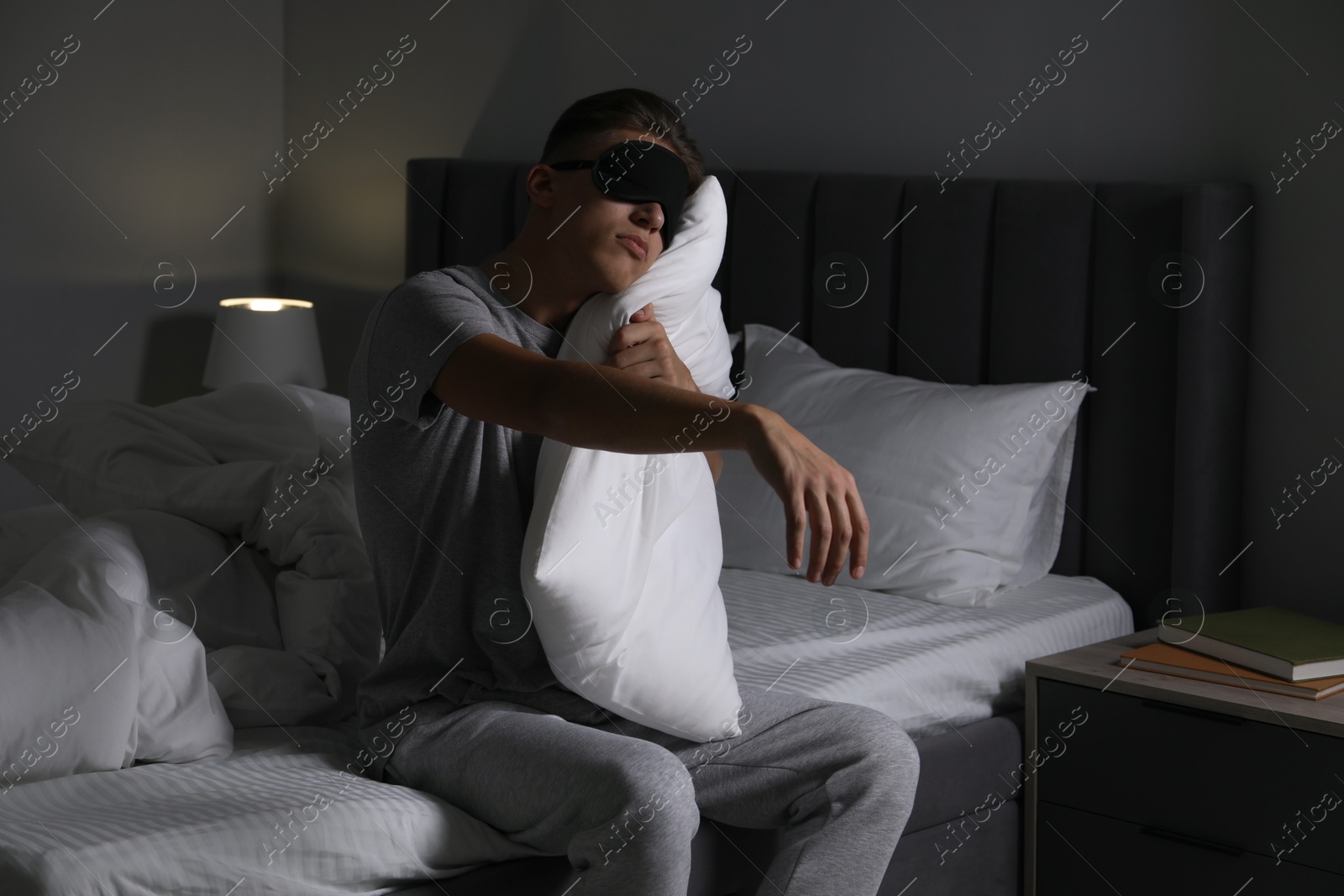 Photo of Young man suffering from sleepwalking on bed at home