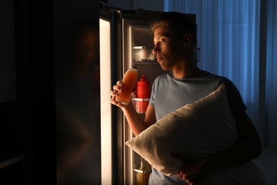 Photo of Young man suffering from sleepwalking near fridge at home