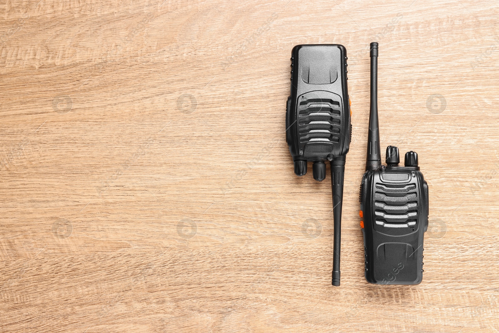 Photo of Walkie talkies on wooden table, top view. Space for text