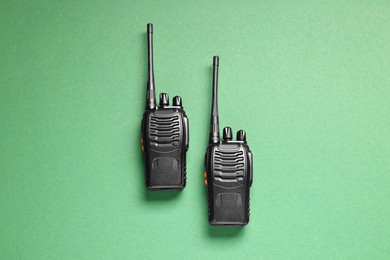 Photo of Walkie talkies on green background, top view