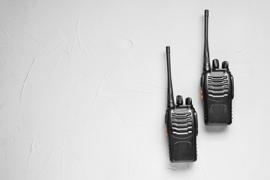 Photo of Walkie talkies on white table, top view. Space for text