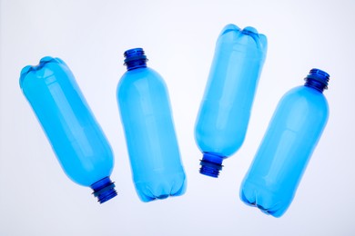 Photo of Empty plastic bottles on white background, top view