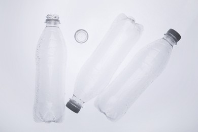 Photo of Empty plastic bottles on white background, top view