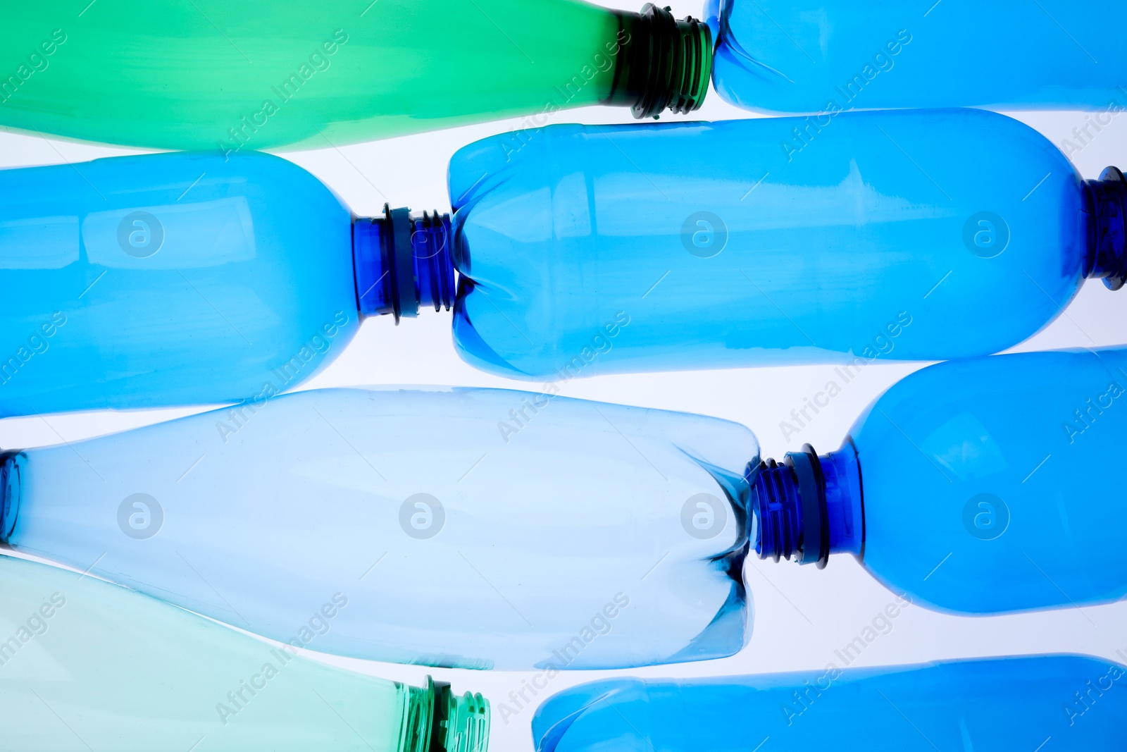 Photo of Empty plastic bottles on white background, top view