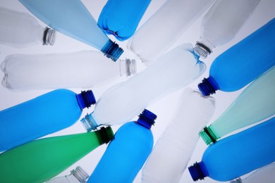 Photo of Empty plastic bottles on white background, top view