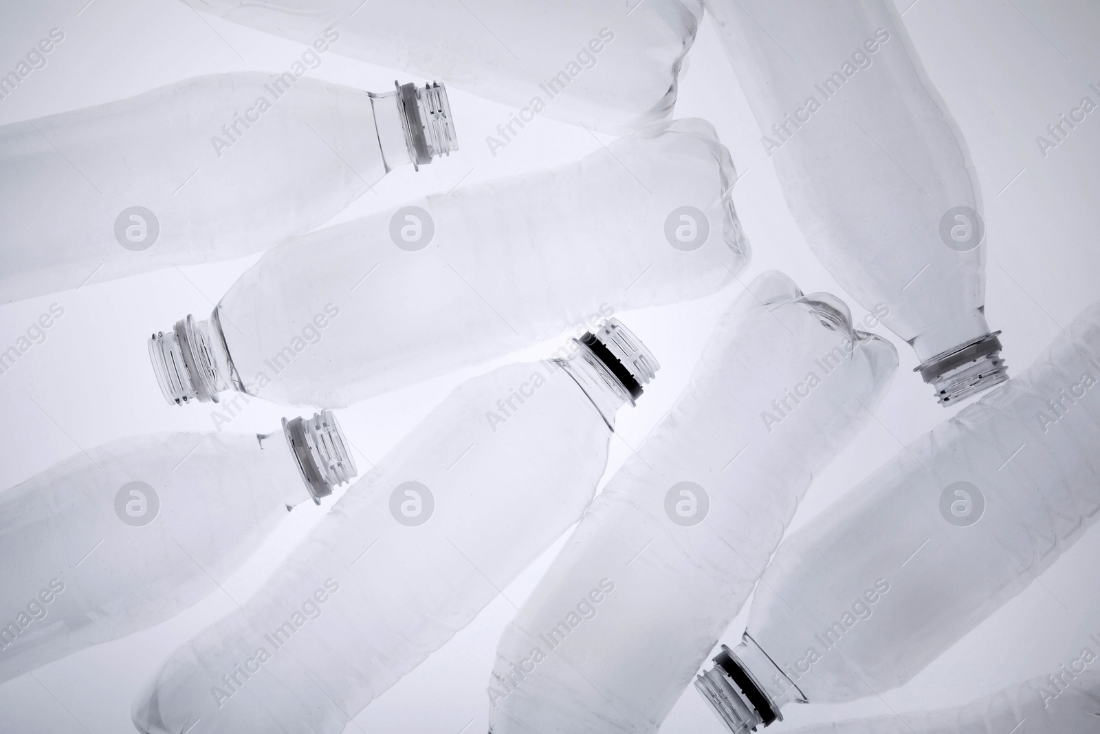 Photo of Empty plastic bottles on white background, top view