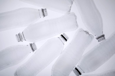 Photo of Empty plastic bottles on white background, top view