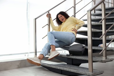 Photo of Injured woman on stairs in building after fall. Dangerous accident