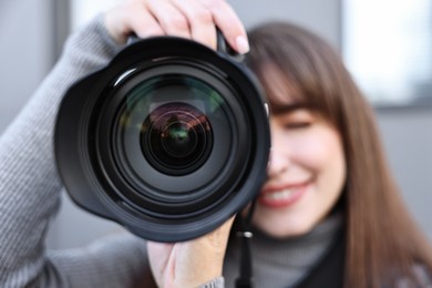 Professional photographer taking picture with camera outdoors, selective focus