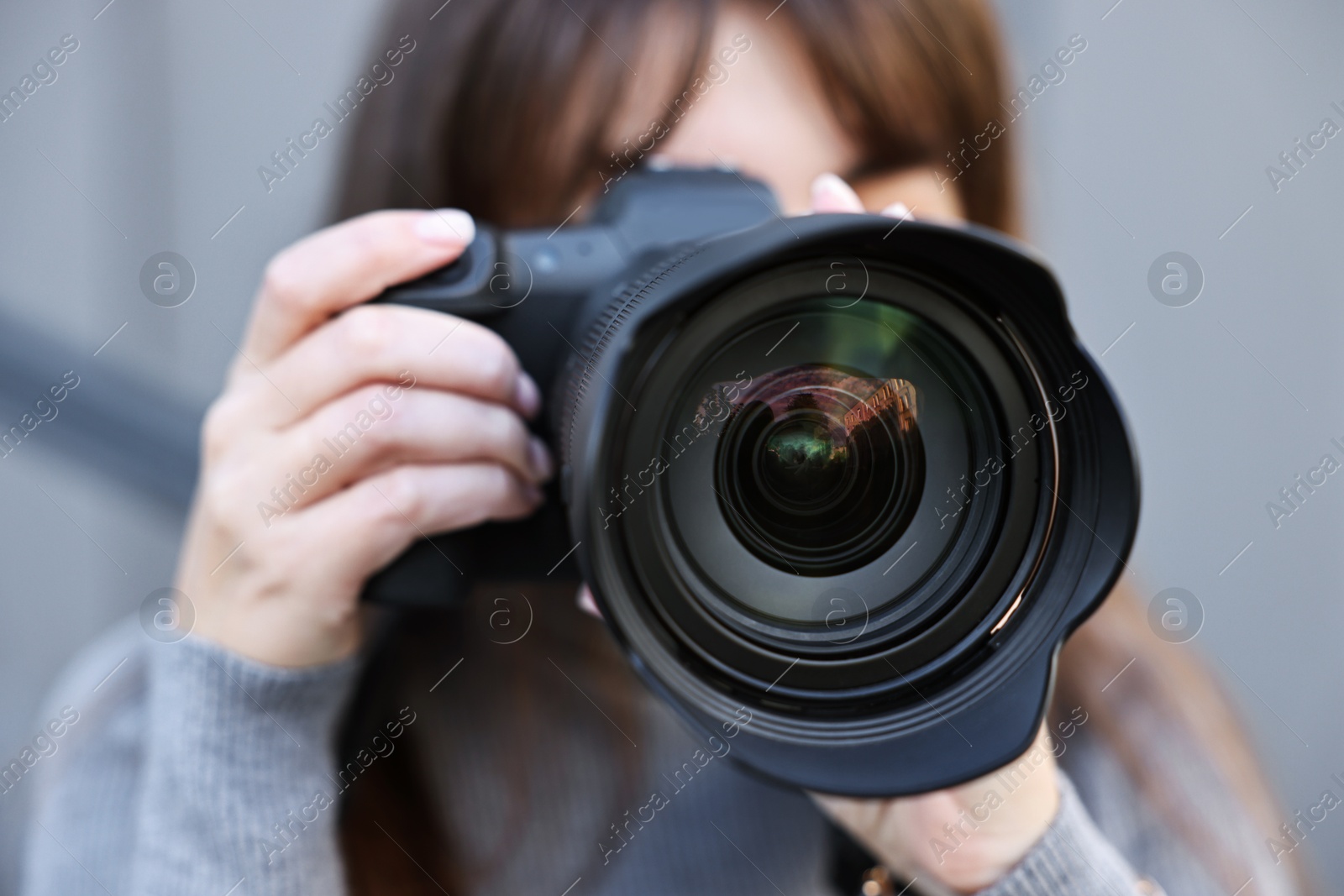 Photo of Professional photographer taking picture with camera outdoors, selective focus