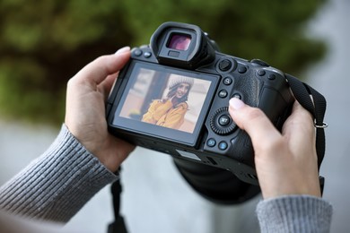 Photo of Professional photographer with digital camera outdoors, closeup