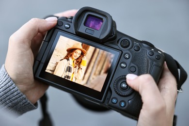 Photo of Professional photographer with digital camera outdoors, closeup