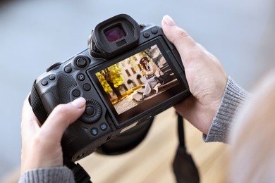 Photo of Professional photographer with digital camera outdoors, closeup