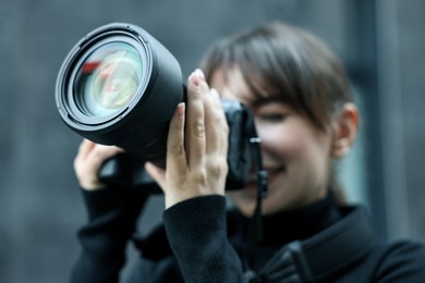 Photo of Professional photographer taking picture with camera outdoors, selective focus