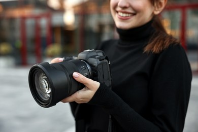 Photo of Professional photographer with digital camera outdoors, closeup