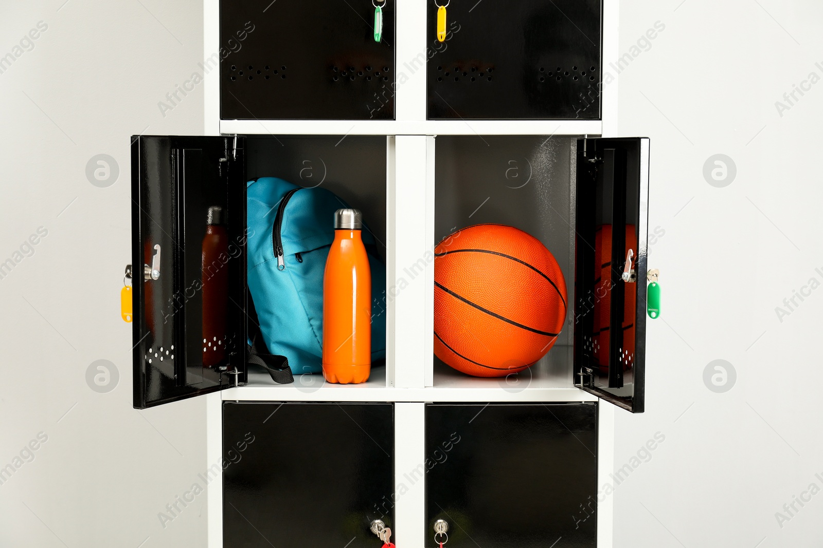 Photo of Lockers with personal belongings in changing room at gym, closeup