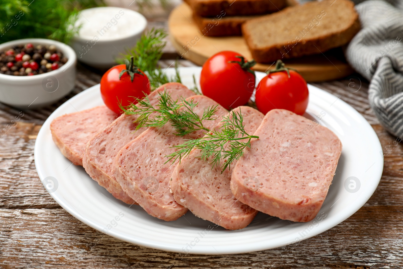 Photo of Tasty canned meat, tomatoes and dill on wooden table, closeup