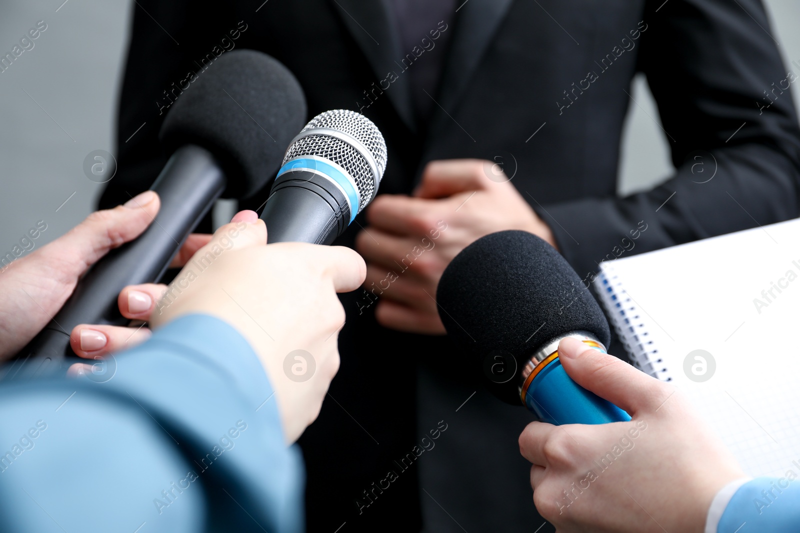 Photo of Group of journalists interviewing businesswoman on grey background, closeup