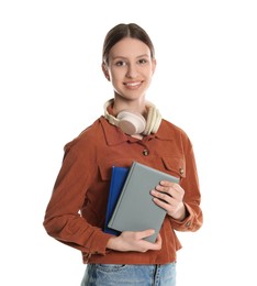 Photo of Portrait of smiling teenage girl with books and headphones on white background