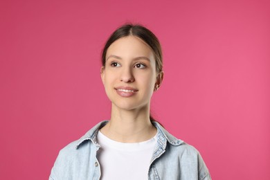 Photo of Portrait of smiling teenage girl on pink background