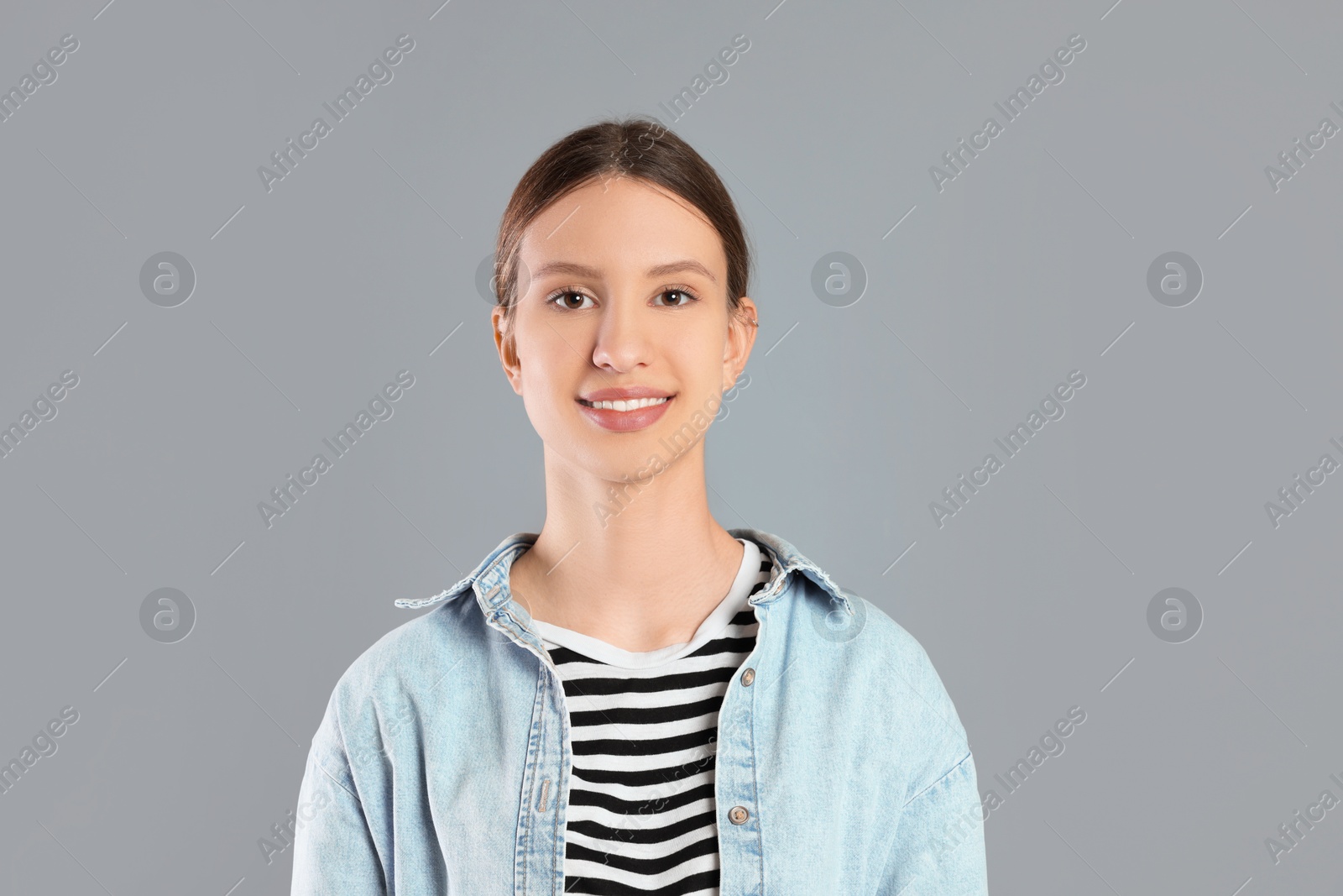 Photo of Portrait of smiling teenage girl on grey background