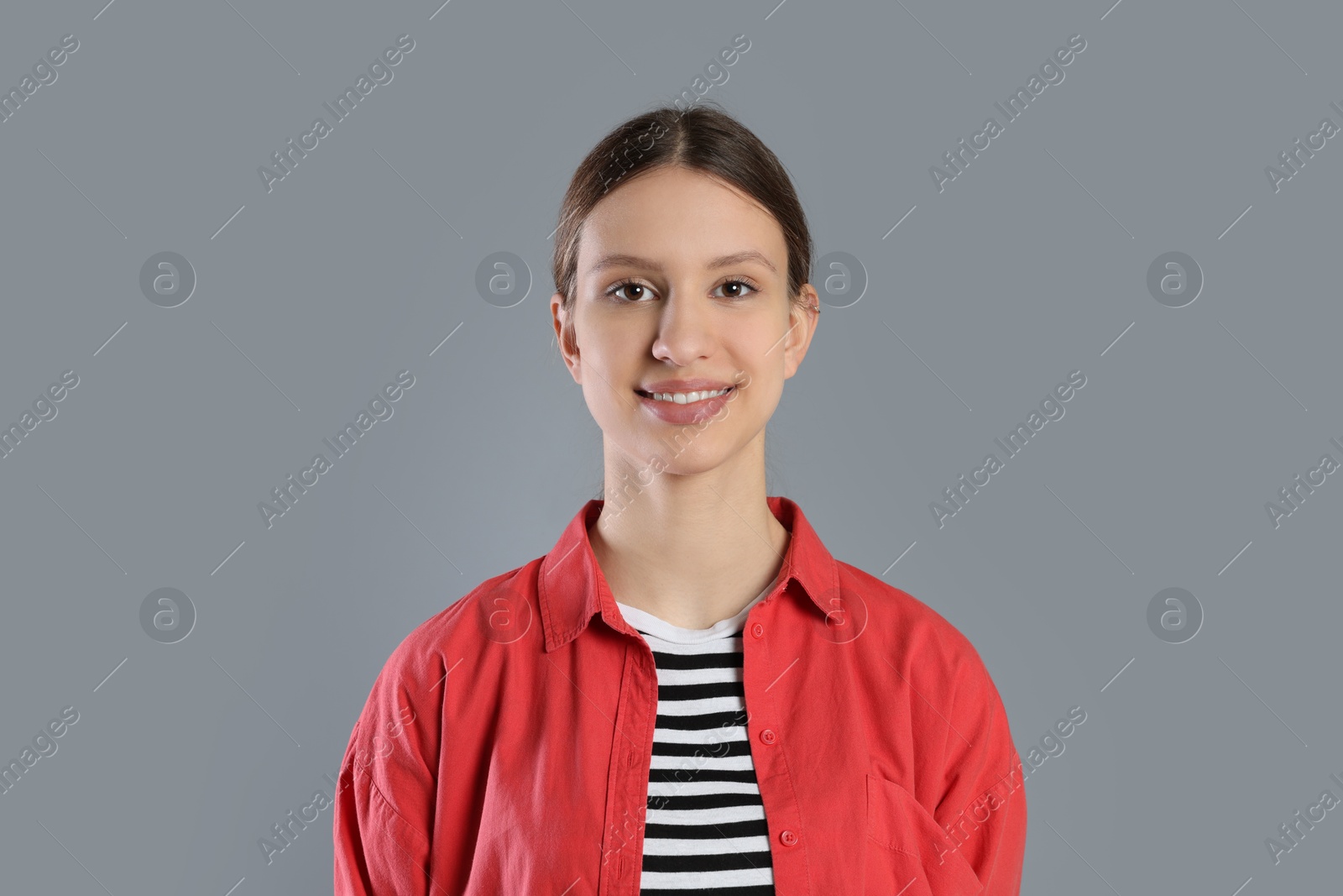 Photo of Portrait of smiling teenage girl on grey background