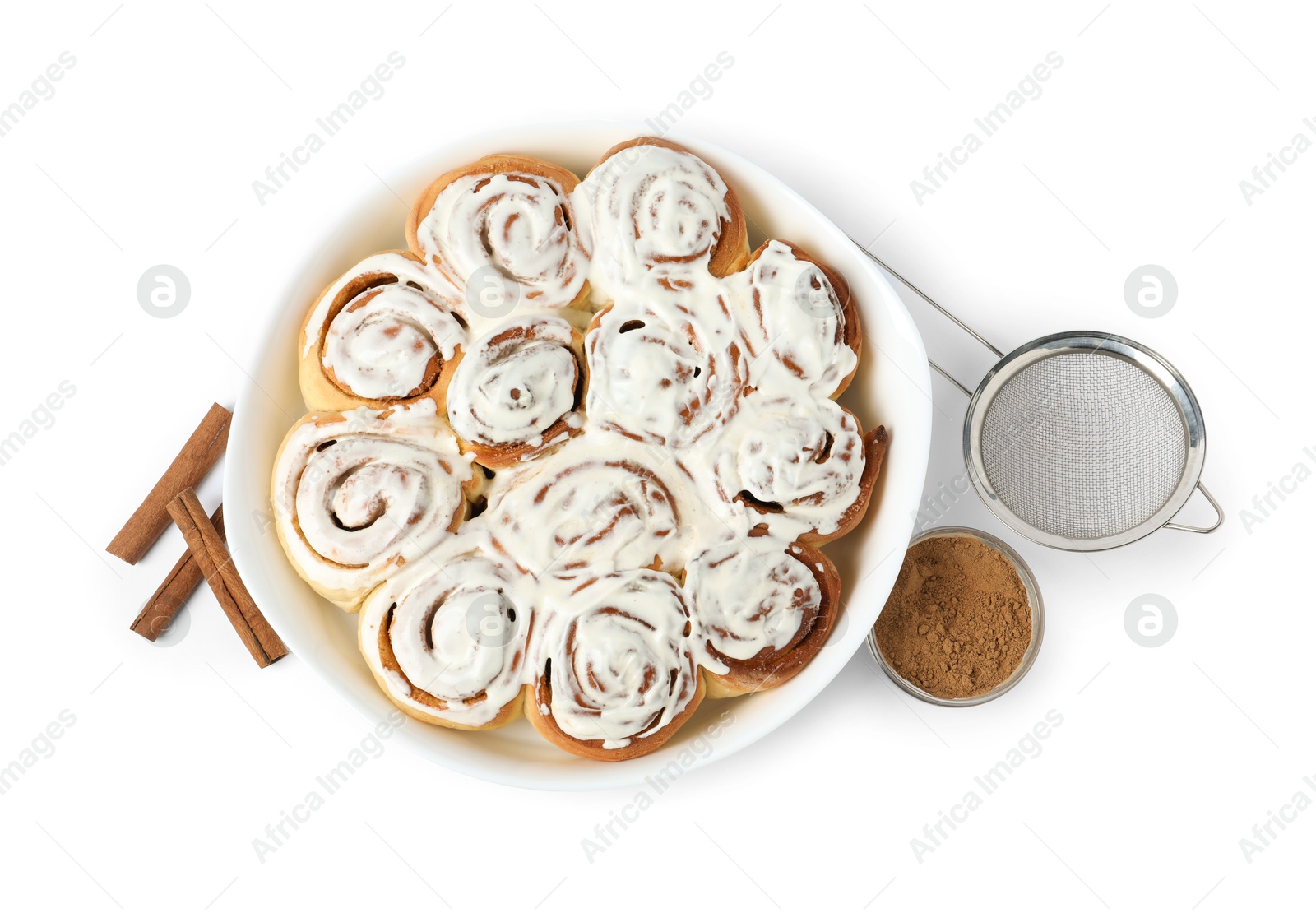 Photo of Delicious frosted cinnamon rolls in baking dish, spices and sieve isolated on white, top view