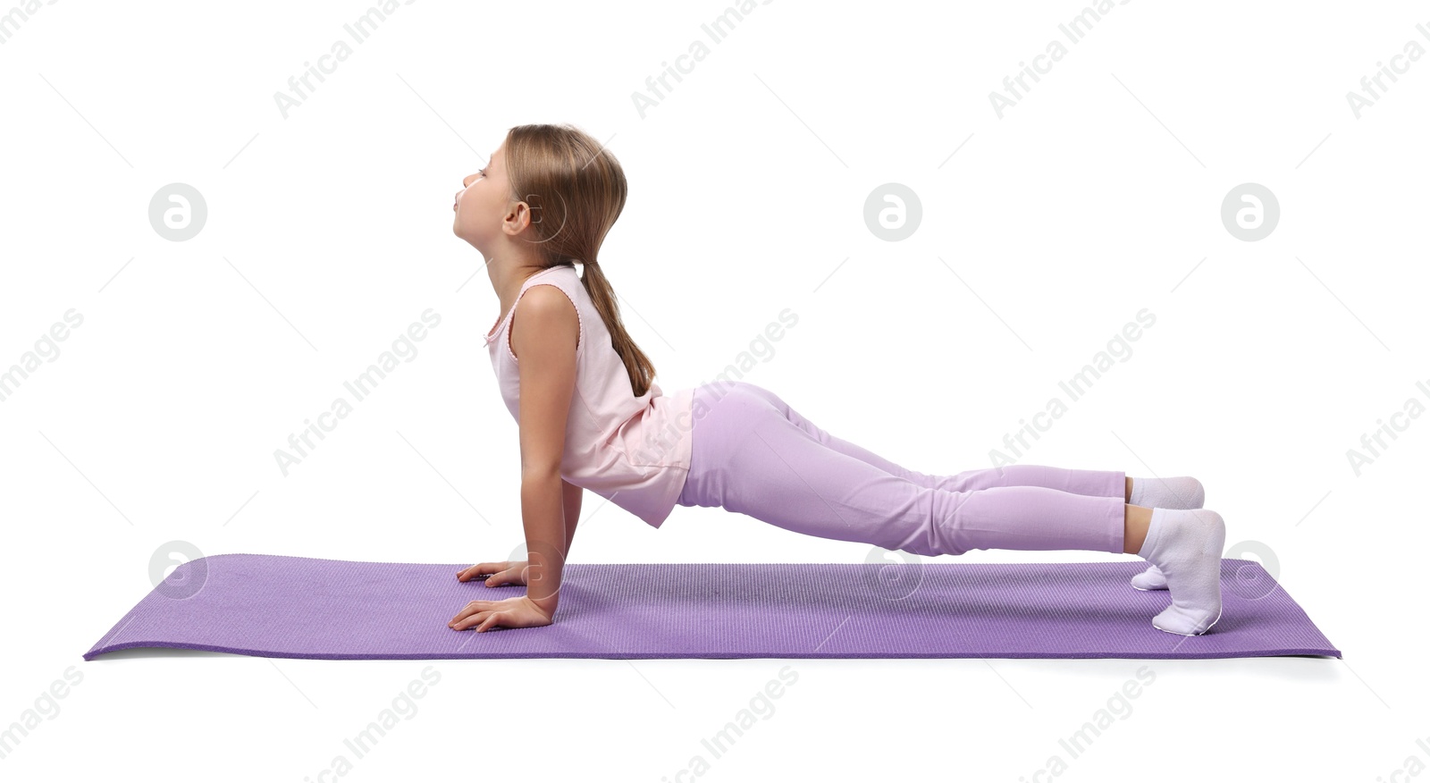 Photo of Little girl exercising on fitness mat against white background