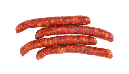 Photo of Many thin dry cured sausages isolated on white, top view